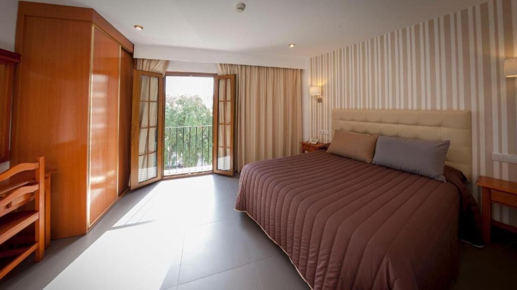Double Room at Hotel Rambla Emérita with a full bed and balcony doors
