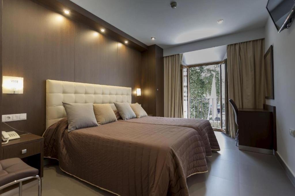 Triple Room at Hotel Rambla Emérita with three beds and a balcony
